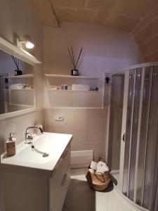 bagno bianco con doccia e lavandino di Casa Lori,73 a Grottaglie