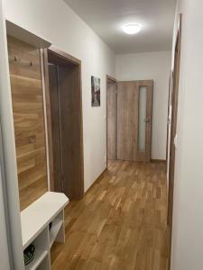 a room with a hallway with wooden floors and a room with a closet at Dvojizbový byt vzdialený 800 m od X Bionic Sphere s dvoma kúpeľňami in Šamorín