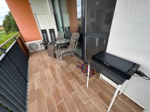 a balcony with a piano and a table and chairs at Dvojizbový byt vzdialený 800 m od X Bionic Sphere s dvoma kúpeľňami in Šamorín