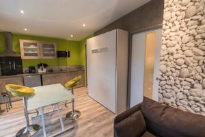 a kitchen and living room with a table and a refrigerator at EPICETOUT in Dannes