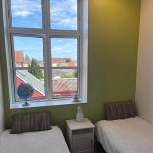 um quarto com 2 camas individuais e uma janela em Den lille Skole - Ferie på Ærø i Marstal by - Værelser em Marstal
