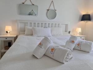 uma cama branca com toalhas e almofadas em REF. 22 CASA NOE em Zahara de los Atunes