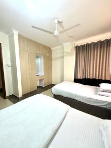 ein Hotelzimmer mit 2 Betten und einem Deckenventilator in der Unterkunft Hillsview Apartment in Voi