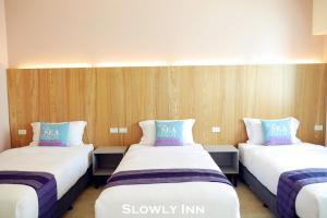 2 Betten in einem Zimmer mit Holzwänden in der Unterkunft Slowly inn in Altstadt von Hengchun