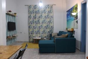 Una sala de estar con un sofá azul y una mesa. en Blue dream, en Komotiní