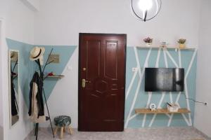 Habitación con puerta marrón y TV en Blue dream, en Komotiní