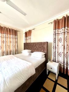 ein Schlafzimmer mit einem großen Bett mit Vorhängen in der Unterkunft Hillsview Apartment in Voi