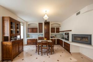 a kitchen with wooden cabinets and a table and chairs at Palazzo Gessi Room and Breakfast in Borghi
