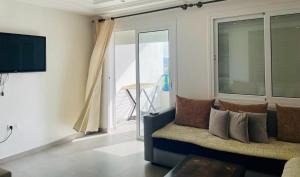 un salon avec un canapé et une grande fenêtre dans l'établissement Kabila Vista par IMMO MARINA Vacances de rêve R, à M'diq