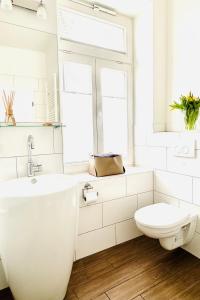 施塔德的住宿－Die Stader Oase mit Sonnenterrasse，白色的浴室设有卫生间和水槽。