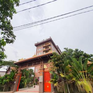 a building in front of a street with trees at Puok Hotel in Phumĭ Puŏk Chăs