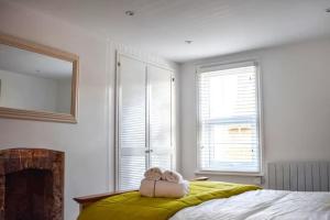 a bedroom with a bed with two towels on it at Beautiful renovated cottage in Mersham Ashford Kent in Mersham