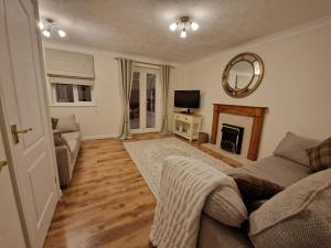 a living room with a couch and a fireplace at Stylish house centrally located in Bury Saint Edmunds