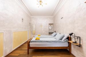 a bedroom with a bed with white walls at Mari&Emi flat in Corvin in Budapest