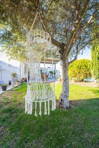 ein weißer Stuhl, der unter einem Baum im Hof sitzt in der Unterkunft DOMAINE DE LA SOURCO - Villa, Maisons & Chalet, Magnifique Havre De Paix En Provence in Trans-en-Provence