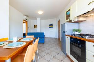 uma cozinha e sala de jantar com uma mesa e um frigorífico em Appartamento Pinolo Trilo INT 10 - MyHo Casa em Alba Adriatica