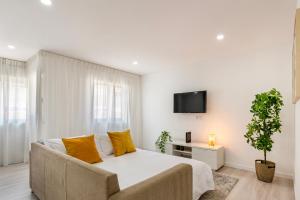 ギマランイスにあるDuke's Apartment - Guimarães Centerの白いベッドルーム(大型ベッド1台、黄色い枕付)