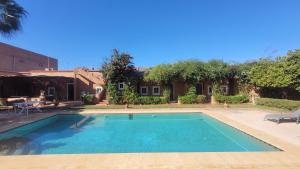 a swimming pool in front of a house at Maison ALPHEA SPA HAMMAM in Marrakesh