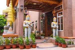 a group of statues standing outside of a building at Puok Hotel in Phumĭ Puŏk Chăs