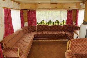 弗瓦迪斯瓦沃沃的住宿－Camping Nadmorski，客厅设有大沙发和红色窗帘
