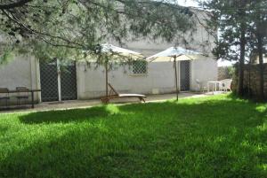 un cortile con panchina e ombrellone di Masseria Frassaniti by My Home Apulia a Veglie
