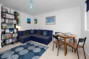 a living room with a blue couch and a table at Light bright & contemporary split-level apartment in Brighton & Hove