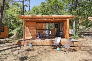 a small cabin with two chairs and a table at Camping La Pinède in Excénevex