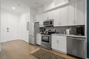 a kitchen with white cabinets and stainless steel appliances at NEW! Sangria Suite - Upscale Ybor City Studio, Right On 7th Ave in Tampa
