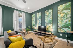 a living room with green walls and a tv at NEW! Sangria Suite - Upscale Ybor City Studio, Right On 7th Ave in Tampa