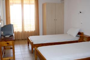 a room with two beds and a tv in it at Ostria in Patitiri
