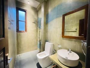 a bathroom with a toilet and a sink and a mirror at The Kheak in Weligama +14 photos