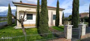una casa blanca con árboles frente a una valla en Casa Clelia, en Ponte Buggianese