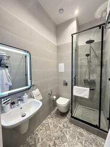 La salle de bains est pourvue d'une douche, d'un lavabo et de toilettes. dans l'établissement Five's Hotel Astana, à Astana