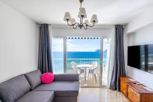 カルプにあるInftour Peñon de Ifach Apartamentoのリビングルーム(ソファ付)が備わり、海の景色を望めます。