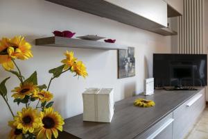 ein Wohnzimmer mit einem Tisch mit Blumen und einem TV in der Unterkunft Free parking - 15 min to Venice in Tessera