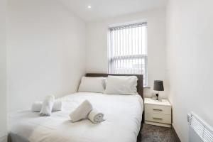 a white bedroom with two beds and a window at Contemporary Budget 1 Bed Apartment in Central Doncaster in Doncaster