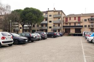a parking lot with cars parked in front of a building at Free parking - 15 min to Venice in Tessera