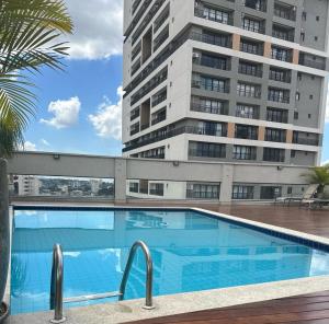 una piscina frente a un edificio alto en SAN MARINO SUITES HOTEL By NOBILE, en Goiânia