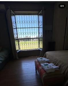 Cette chambre comprend un lit et une grande fenêtre. dans l'établissement La mancha verde casa de campo, à Capitán Sarmiento