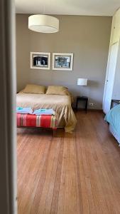 1 dormitorio con 1 cama y suelo de madera en La mancha verde casa de campo in 