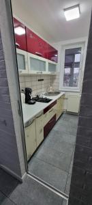 a kitchen with red and white cabinets and a sink at Feel Like Home 2 in Piatra Neamţ