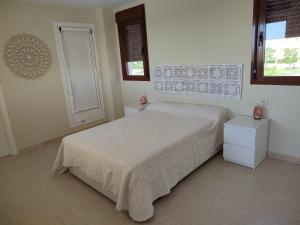 - une chambre blanche avec un lit et une fenêtre dans l'établissement Apartamento Panoramica Golf, à Sant Jordi