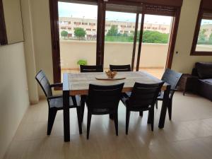 - une table à manger et des chaises dans le salon dans l'établissement Apartamento Panoramica Golf, à Sant Jordi