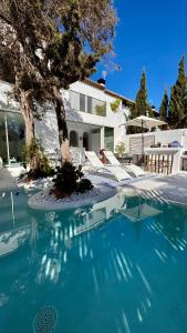 een zwembad met een boom en een huis bij Casa Blu Marbella in Marbella