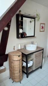 W łazience znajduje się umywalka i lustro. w obiekcie Couleurs du temps - pres Giverny w mieście Limetz