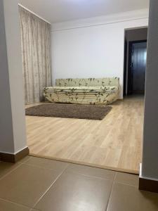 a living room with a couch in the corner of a room at Apartament central in Râmnicu Vâlcea +1 photo