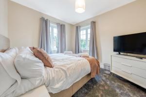a bedroom with a bed and a flat screen tv at Spectacular House with Parking in Chorley