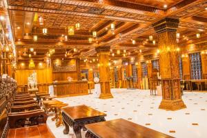 a large room with wooden tables and chairs at Puok Hotel in Phumĭ Puŏk Chăs