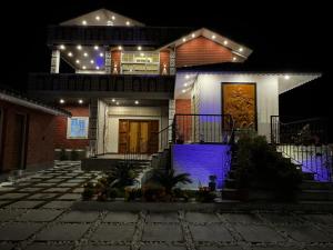 a house with lights on the front of it at night at Chaitali The Villa in Shānti Niketan