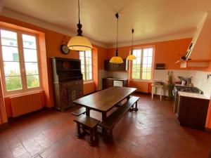 a kitchen with orange walls and a wooden table at Guethary centre, Maison de Famille 10 couchages, classée 3 étoiles in Guéthary